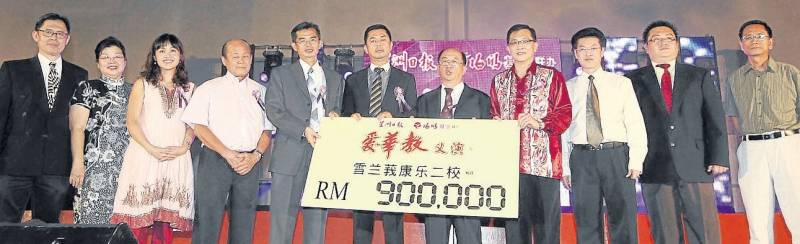 在众贵宾的陪同下，许春（右4四）代表移交90万令吉的支票予康乐二校代表，由麦富炜（左5起）代表接领、麦洪荣与莊新贵见證。左起：刘添水、郑宝琼、张念群与黄金，右起：卜亚烈、陈明