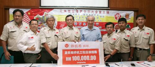 陈凯希（右4）将10万令吉的模拟支票交给翁清玉（左4），左起是江坤粦、蓝傑豪、陈松青，右起为刘志华、韩学林及吴国文。