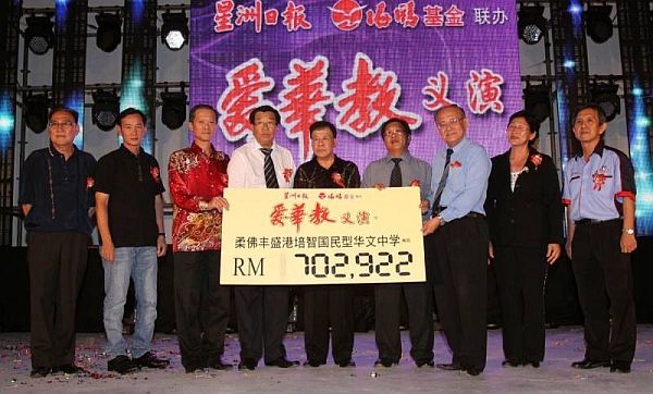 在黄世忠（右5）的见證下，符传曙（右3）与陈笃功（左3）将70万2千922令吉的模拟支票移交给郑金发（左四）及陈伟光（右4）。右起：陈鼎星、郭丽娇。左起：郑松章、戴江帆。