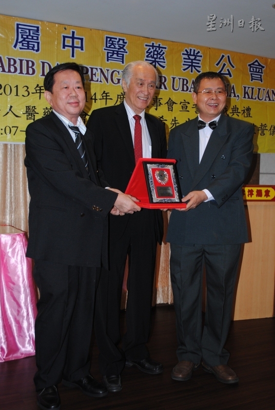 居銮属中医药业公会会长萧福良（右）和署理会长卢建良（左）联合赠送纪念品给监誓人陈凯希（中）。