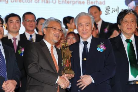“卓越楷模年度人物奖＂得主陈凯希从颁奖者阿末胡斯尼（左）手中接获奖座。