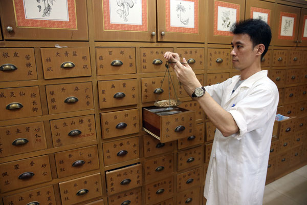 A clerk weighs traditional Chinese medicine in a Tongrentang pharmacy in Kuala Lumpur, Malaysia, in November.
