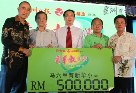 出德隆（中）移交50万令吉模拟支票给高铭良（左一），左二为林尔成，右一起为吴锦利及叶逢春。