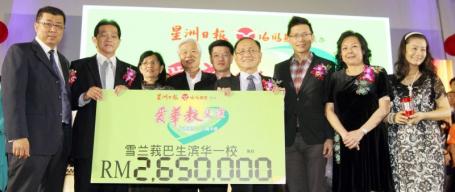 颜来发（左二）移交265万令吉模拟支票给颜金松（右四）。左一为陈永镇，左叁起为谢木兰、谢松坤和陈祈福；右一起为胡长荣、冯瑞雯和陈金泉。