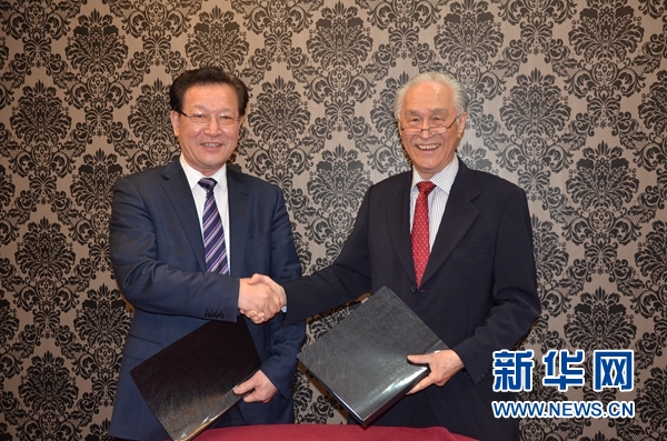 Director manager of Malaysian Hai-O Group Tan Khai Hee (right) and general manager of Xinhuanet Malaysia Channel Xia Baowen sign official cooperative agreement in Bandar Klang, Malaysia, Jan. 22, 2014