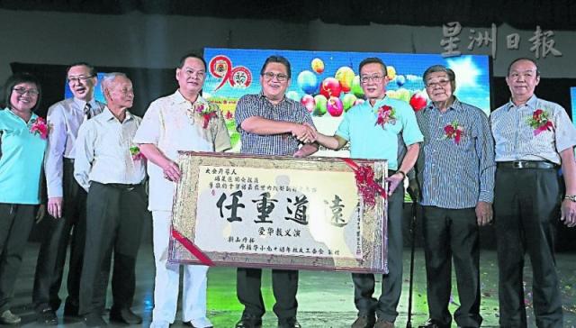 梁永禄（右三）赠送“任重道远”字画给诺加兹兰（右四）。左起是何少娟、出德隆、郑其仁、陈金福；右起是苏文吉、曾振强。