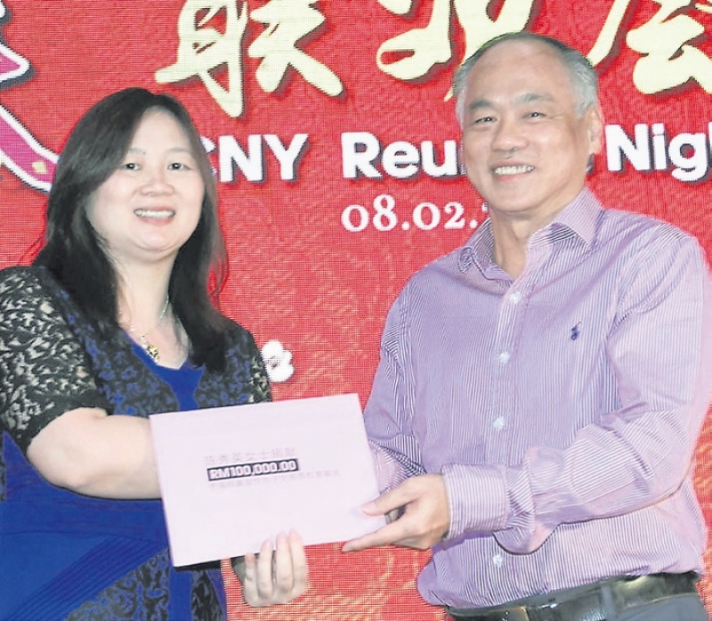 陈景岗夫人潘华英（左）代表陈秀英移交10万令吉予海鸥基金，由丘观庆接领。