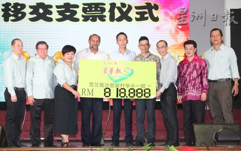 “爱华教义演”成功为沙登新村华小一校筹获81万8888令吉，廖志明（右三起）在陈金泉、欧阳捍华及哥宾星等嘉宾见证下，移交模拟支票予方丽香。左起为郑德君及黄稳全；右起为练贵祥及陈祈福。