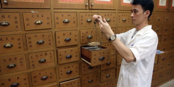 A clerk weighs traditional Chinese medicine in a Tongrentang pharmacy in Kuala Lumpur, Malaysia, in November.