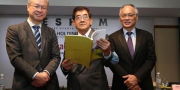 陈景岗（左起）、黄泽荣和丘观庆共同翻阅着公司年报。